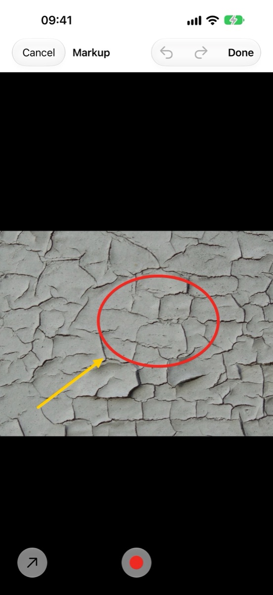 Photo markup editor with a circle and an arrow drawn on a wall photo